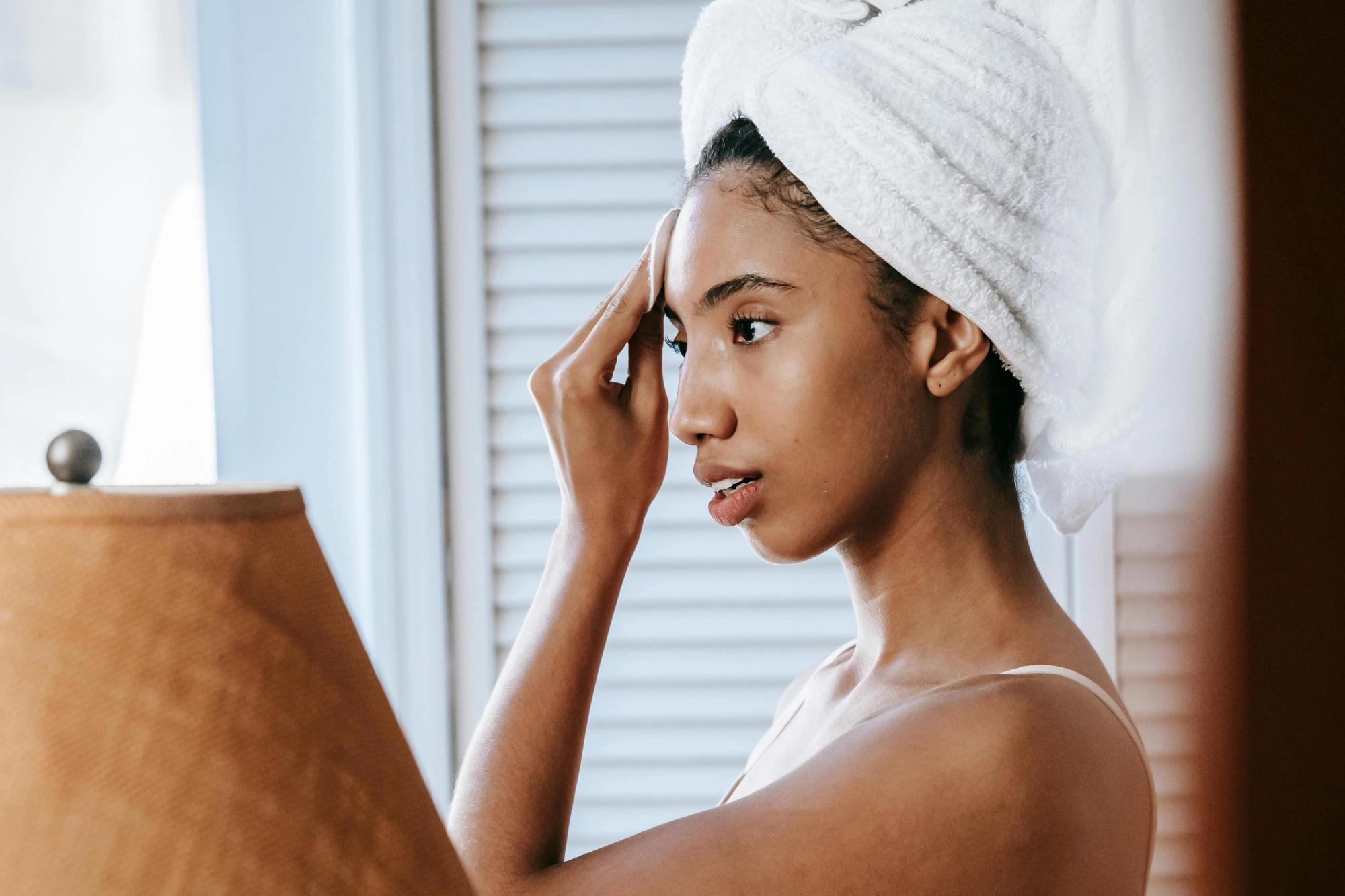 Woman applying skincare after cleansing to help reduce the appearance of pores and smooth skin