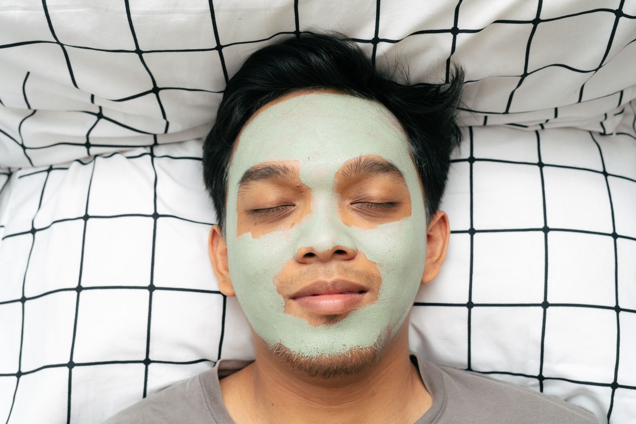 A young man goes to bed with a Korean skincare mask on his face