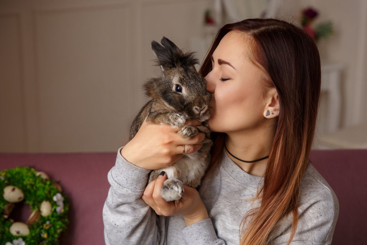 A young woman gives a bunny a kiss on the cheek