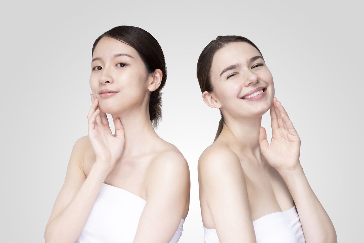 Two young women smile and show off the smooth texture of their clean skin